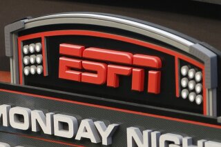 FILE - This Sept. 16, 2013, file photo shows the ESPN logo prior to an NFL football game between the Cincinnati Bengals and the Pittsburgh Steelers, in Cincinnati. ESPN is reminding employees of the network's policy to avoid talking about politics after radio talk show host Dan Le Batard criticized President Donald Trump and his recent racist comments and ESPN itself on the air this week. (AP Photo/David Kohl, File)