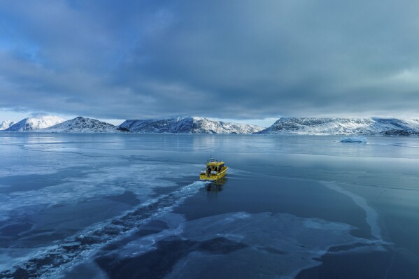 A boat rides though a frozen sea inlet outside of Nuuk, Greenland, March 6, 2025. (AP Photo/Evgeniy Maloletka)