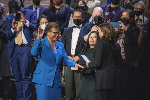 Karen Bass, left, is sworn in as mayor of Los Angeles by Vice President Kamala Harris, a longtime friend and former California attorney general, in Los Angeles, on Sunday, Dec. 11, 2022. Bass' stepdaughter, Yvette Lechuga, center, holds the Bible used in the swearing in. (AP Photo/Damian Dovarganes)