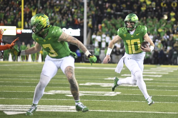 Oregon quarterback Bo Nix (10) runs for a touchdown during the first half of an NCAA college football game against Oregon State, Friday, Nov. 24, 2023, in Eugene, Ore. (AP Photo/Mark Ylen)