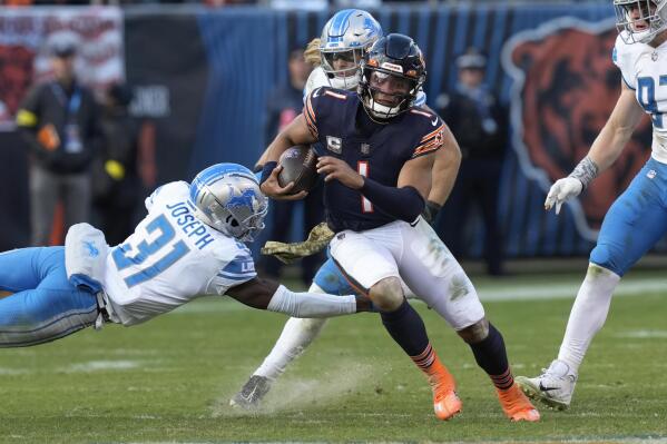 Chicago Bears quarterback Justin Fields (1) evades Detroit Lions safety Kerby Joseph (31) running for a 67-yard touchdown during the second half of an NFL football game in Chicago, Sunday, Nov. 13, 2022. (AP Photo/Charles Rex Arbogast)