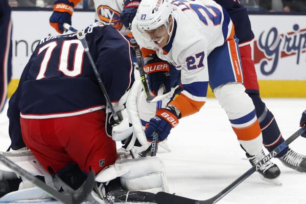 Columbus Blue Jackets goalie Joonas Korpisalo, left, stops a shot in front of New York Islanders forward Anders Lee during the first period of an NHL hockey game in Columbus, Ohio, Friday, Nov. 25, 2022. (AP Photo/Paul Vernon)