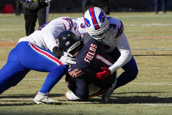 Chicago Bears quarterback Justin Fields (1) is tackled for a loss by Buffalo Bills safety Damar Hamlin (3) in the first half of an NFL football game in Chicago, Saturday, Dec. 24, 2022. (AP Photo/Charles Rex Arbogast)