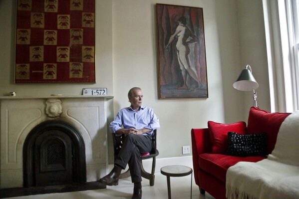 FILE - British novelist Martin Amis poses in the living room of his new home in the Brooklyn borough of New York on Aug. 17, 2012. Martin Amis, one of the most consequential British authors of his generation and who died last month, has been posthumously knighted by King Charles III in his first birthday honors list, which were unveiled late Friday, June 16, 2023. (AP Photo/Bebeto Matthews, File)