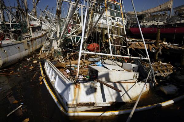 Damaged shrimp boats and debris litter the waterfront and the pier at Erickson & Jensen Seafood following the passage of Hurricane Ian, on San Carlos Island in Fort Myers Beach, Fla., Friday, Oct. 7, 2022. (AP Photo/Rebecca Blackwell)
