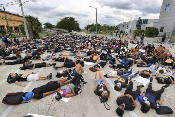 Protestors lie down on South Street in front of the Orlando Police Department in Orlando, Fla., Friday, June 5, 2020. The protests continue in Orlando on Friday over the death of George Floyd when he was in police custody in Minneapolis on May 25. (Joe Burbank/Orlando Sentinel via AP)