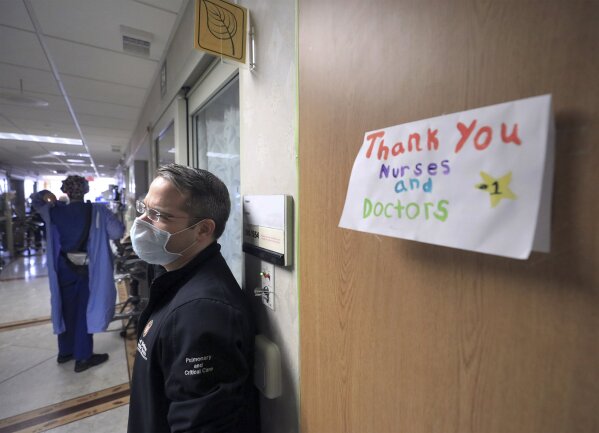 FILE - In this Nov. 5, 2020, file photo, a thank you note for staff at UW Health is displayed on a wall inside a COVID-19 treatment unit as Dr. Andrew Braun, a physician on the unit stands by in Madison, Wis. Conditions inside the nation’s hospitals are deteriorating by the day as the coronavirus rages through the country at an unrelenting pace. (John Hart/Wisconsin State Journal via AP, File)