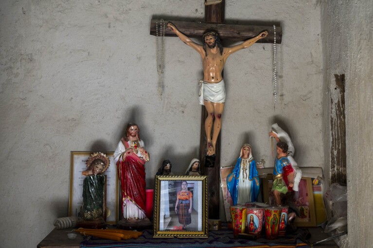A portrait of Blanca Ramírez Crisostomo stands on an altar at her parent's home in the Loma Linda hamlet of Comitancillo, Guatemala, Monday, March 18, 2024. The 23-year-old died on her third attempt to reach the U.S., alongside 50 other migrants, asphyxiated in a smuggler’s tractor-trailer in San Antonio, Texas in June, 2022. (AP Photo/Moises Castillo)