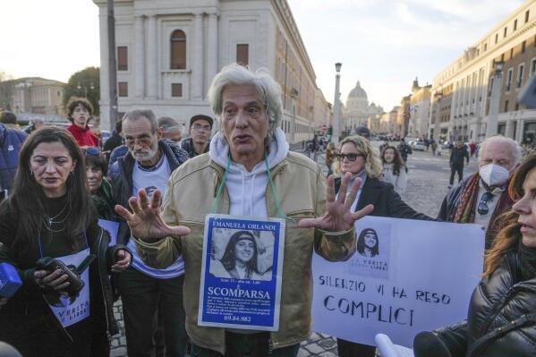FILE - Pietro Orlandi wears a placard with a picture of his sister Emanuela during a sit-in near Saint Peter's Basilica, in Rome, Saturday, Jan. 14, 2023. One of the Vatican’s enduring mysteries took another twist Friday, April 14, 2023, with the Vatican pushing back hard against “slanderous” insinuations that St. John Paul II was involved in a molesting young girls. (AP Photo/Gregorio Borgia, File)