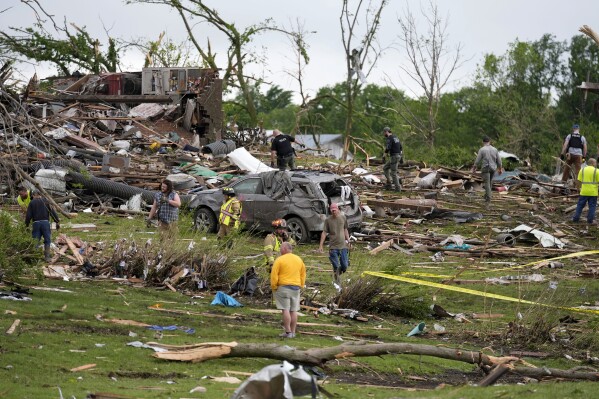 Trabajadores buscan entre los restos de las casas dañadas por el tornado, el martes 21 de mayo de 2024, en Greenfield, Iowa. (AP Foto/Charlie Neibergall)