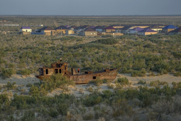 A rusting ship sits in a dried-up area of the Aral Sea in Muynak, Uzbekistan, Sunday, June 25, 2023. (AP Photo/Ebrahim Noroozi)