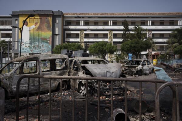 Burned cars are seen at the entrance of the Cheikh Anta Diop University after authorities ordered the institution to be closed until further notice in Dakar, Senegal, Friday, June 2, 2023. Clashes between police and supporters of Senegalese opposition leader Ousmane Sonko left nine people dead, the government said Friday, with authorities issuing a blanket ban on the use of several social media platforms in the aftermath of the violence. (AP Photo/Leo Correa)