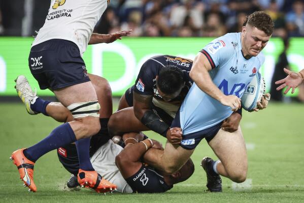 Tom Lambert, right, from the New South Wales Waratahs is tackled by Blake Schoupp, left, from ACT Brumbies during their Super Rugby Pacific Round 1 match at Allianz Stadium in Sydney, Australia Friday, Feb. 24, 2023. (David Gray/AAP Image via AP)