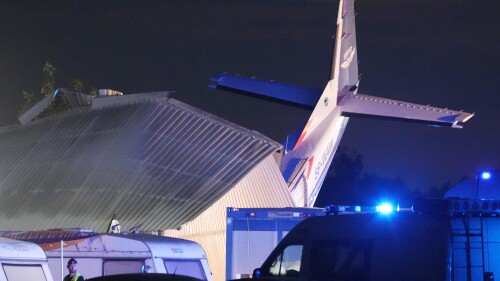 The tail of a Cessna 208 plane sticks out of a hangar after it crashed there in bad weather killing several people and injuring others, at a sky-diving center in Chrcynno, central Poland, on Monday, July 17, 2023. (AP Photo/Czarek Sokolowski)