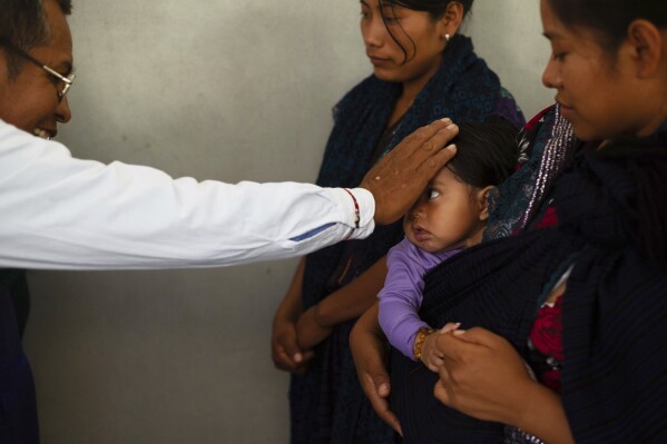Deacon Juan Pérez Gómez bestows a blessing on a child during a Mass honoring the late Pope Francis in the Simojovel municipality, Mexico, Sunday, April 27, 2025. (AP Photo/Isabel Mateos)