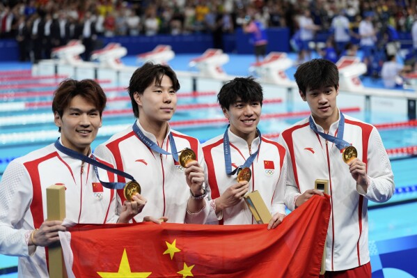 China's Xu Jiayu, Qin Haiyang, Sun Jiajun, and Pan Zhanle pose for a photo with their gold medals during the awards ceremony for the men's 4x100-meter medley relay at the Summer Olympics in Nanterre, France, Sunday, Aug. 4, 2024. (AP Photo/Brynn Anderson)