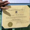 Jamarques Harrison, 28, holds his diploma backdated to Aug. 3, 2013, after graduating with the class of Springfield Preparatory School at Victory in Christ church in Holden, La., Saturday, Aug. 5, 2023. Nearly 9,000 private schools in Louisiana don’t need state approval to grant degrees. Non-approved schools make up a small percentage of the state total. But the students in Louisiana’s off-the-grid school system are a rapidly growing example of the national fallout from COVID-19 — families disengaging from traditional education. (AP Photo/Matthew Hinton)