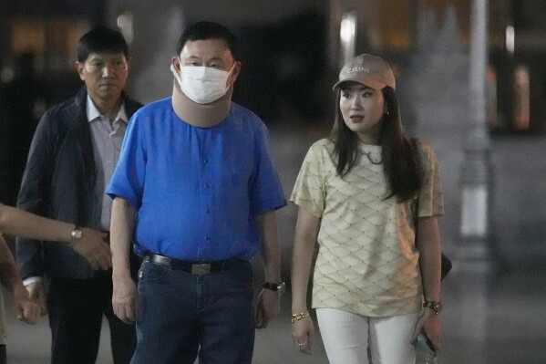 Former Thai Prime Minister Thaksin Shinawatra, center, and his daughter Paetongtarn Shinawatra, right, visit City Pillar Shrine in Bangkok, Thailand, Thursday, March 14, 2024. Earlier in February, he was released on parole from a hospital where he spent six months serving time for corruption-related offenses. (AP Photo/Sakchai Lalit)