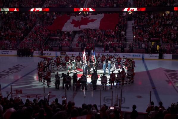 Anthem singer Lyndon Slewidge holds up the microphone as the crowd sings 'O Canada' before the NHL hockey game between the Ottawa Senators and New Jersey Devils, Saturday, Oct. 25, 2014 in Ottawa, Ontario. (AP Photo/The Canadian Press, Adrian Wyld)