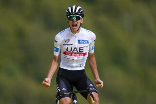 FILE - Slovenia's Tadej Pogacar, wearing the best young rider's white jersey, celebrates as he crosses the finish line to win the twentieth stage of the Tour de France cycling race over 133.5 kilometers (83 miles) with start in Belfort and finish in Le Markstein Fellering, France, Saturday, July 22, 2023. Tour de France winner Tadej Pogacar announced Sunday, Dec, 17, 2023 that he has added the Giro d’Italia to his program for the upcoming season. (AP Photo/Daniel Cole, File)