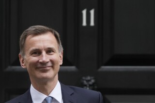 FILE - Britain's Chancellor of the Exchequer Jeremy Hunt poses for the media as he leaves 11 Downing Street for the House of Commons to deliver the Budget In London, Wednesday, March 15, 2023. U.K. Treasury chief Jeremy Hunt says the government can afford to lower some taxes now that inflation is falling, but that any cuts will come along with a squeeze on welfare benefits. (AP Photo/Frank Augstein, File)