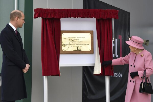 Britain's Prince William looks on as Queen Elizabeth II unveils a plaque to officially open the new Energetics Analysis Centre at the Defence Science and Technology Laboratory (DSTL) at Porton Down, England, Thursday Oct. 15, 2020, to view the Energetics Enclosure and display of weaponry and tactics used in counter intelligence. (Ben Stansall/Pool via AP)