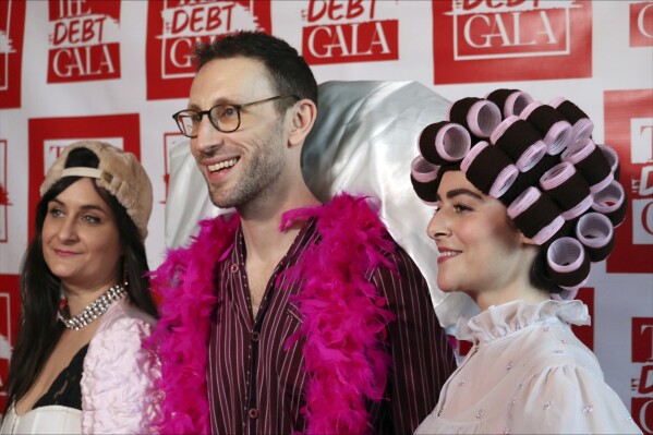 Debt Gala co-founders, from left, Molly Gaebe, Tom Costello and Amanda Corday, appear at the Debt Gala in the Brooklyn borough of New York on Sunday, May 5, 2024. Some 200 attendees sought to help alleviate medical debt at the second annual benefit, one of several alternative fundraisers that have popped up around the star-studded Met Gala. (AP Photo/James Pollard)