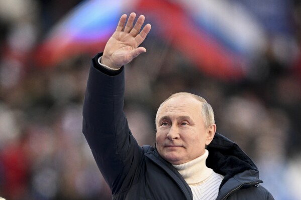 FILE - Russian President Vladimir Putin waves people after delivering his speech at the concert marking the eighth anniversary of the referendum on the state status of Crimea and Sevastopol and its reunification with Russia, in Moscow, Russia, Friday, March 18, 2022. Vladimir Putin isn't quite the man he used to be — more than a decade has passed since the Russian president engaged in public stunts to boast of his vigor by hugging a polar bear or riding a horse barechested in the mountains. (Ramil Sitdikov/Sputnik Pool Photo via AP, File)