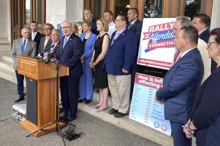 Connecticut state Sen. Kevin Kelly, at podium, the minority leader of the state Senate, speaks to reporters outside the Connecticut State Capitol in Hartford, Conn., Tuesday, June 7, 2022, about a Republican plan to cut taxes. Kelly is joined by House Minority Leader Vincent Candelora, third left, and GOP House and Senate members who called on Democratic leaders to hold a special session to vote on more than $746 million in reductions, in addition to tax cuts already included in the latest state budget. (AP Photo/Susan Haigh)