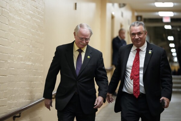 Rep. John Rutherford, R-Fla., left, and Rep. Don Bacon, R-Neb., right, arrive for the Republican caucus meeting at the Capitol in Washington, Thursday, Oct. 19, 2023. (AP Photo/Alex Brandon)