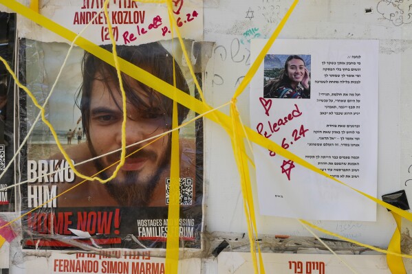CORRECTS AGES: Pictures of rescued hostages who were kidnapped in a Hamas-led attack on Oct. 7. Andrey Kozlov, 27, and Noa Argamani, 26, hang on a wall in Tel Aviv, Israel, Saturday, June 8, 2024. Israel said Saturday it rescued four hostages who were kidnapped in the Hamas-led attack on Oct. 7, the largest such recovery operation since the war began in Gaza. (AP Photo/Ohad Zwigenberg)