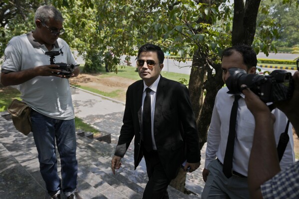 Naeem Haider Panjutha, center, a lawyer of Pakistan's former Prime Minister Imran Khan's legal team, arrives at a court to file petition against Khan's conviction, in Islamabad, Pakistan, Tuesday, Aug. 8, 2023. The lawyers for Khan petitioned a top court in the capital, Islamabad, on Tuesday, seeking the suspension of his conviction and sentencing of three years in jail in a graft case and requesting his release, a spokesman for the former premier's legal team said. (AP Photo/Anjum Naveed)