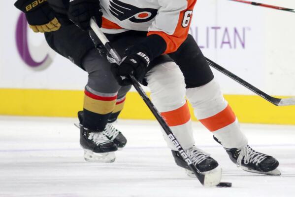 Philadelphia Flyers defenseman Travis Sanheim (6) has control of the puck around Vegas Golden Knights right wing Keegan Kolesar (55) in the first period of an NHL hockey game Friday, Dec. 10, 2021, in Las Vegas. (AP Photo/Ronda Churchill)