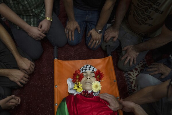 Palestinians take the last look at the body of Ayham Shafe'e, 14, during his funeral in the West Bank city of Ramallah, Thursday, Nov. 2, 2023. Shafee and a second Palestinian man were killed during an Israeli army raid in Ramallah early morning, the Palestinian Health Ministry said.(AP Photo/Nasser Nasser)