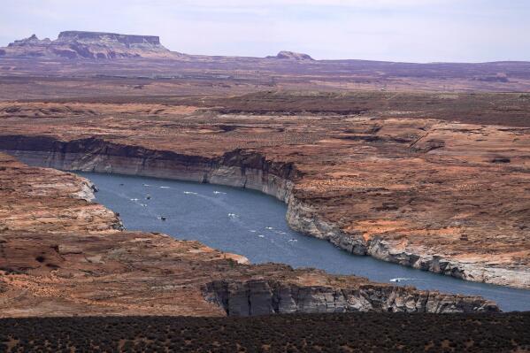 FILE - Boats move along Lake Powell in the Upper Colorado River Basin on June 9, 2021, in Wahweap, Ariz. Federal officials are funneling more money to rural water projects in several states as the Biden administration looks to put a dent in growing infrastructure needs amid drought and climate change. The U.S. Interior Department announced Thursday, March 31, 2022 that $420 million will be spent on projects in New Mexico, Minnesota, Montana, North Dakota, South Dakota and Iowa. (AP Photo/Ross D. Franklin, File)