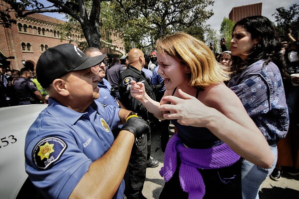 FILE - A University of Southern California protester, right, confronts a University Public Safety officer at the campus' Alumni Park during a pro-Palestinian occupation, Wednesday, April 24, 2024, in Los Angeles. (AP Photo/Richard Vogel, File)