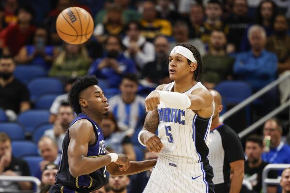 Orlando Magic forward Paolo Banchero (5) passes the ball while defended by Indiana Pacers forward Aaron Nesmith (23) during the first half of an NBA basketball game Wednesday, Jan. 25, 2023, in Orlando, Fla. (AP Photo/Kevin Kolczynski)