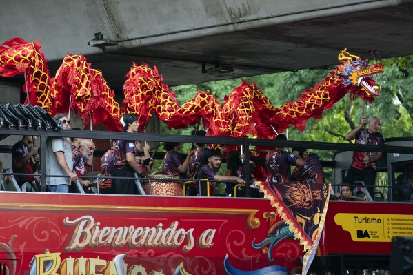 People hold a Dragon puppet during the Chinese New Year celebrations, marking the year of the snake, in Buenos Aires, Argentina, Saturday, Jan. 25, 2025. (AP Photo/Rodrigo Abd)