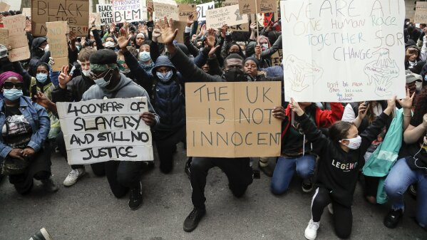 FILE - In this file photo dated Saturday, June 6, 2020, demonstrators gather outside Downing Street during a Black Lives Matter march in London.  A government inquiry, by a panel of experts, has concluded Wednesday March 31, 2021, that there is racism in Britain, but it’s not a systematically racist country that is “rigged” against non-white people, though many ethnic-minority Britons greeted that claim with skepticism.  (AP Photo/Frank Augstein, FILE)