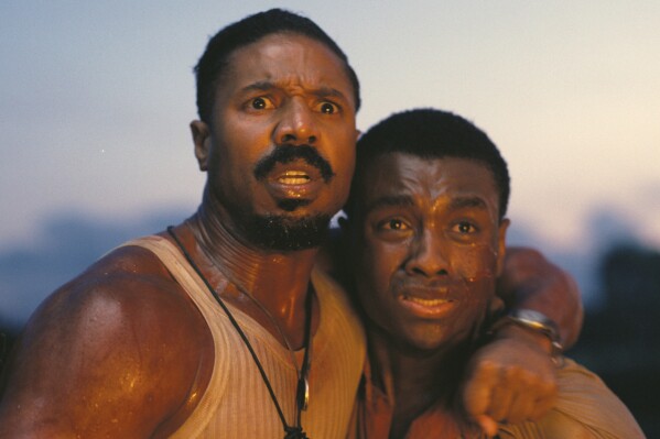 This image released by Warner Bros Pictures shows Michael B. Jordan, left, and Miles Caton in a scene from "Sinners." (Warner Bros. Pictures via AP)