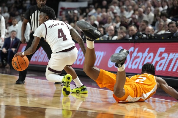 Texas A&M guard Wade Taylor IV (4) gets a loose ball as Tennessee guard Jordan Gainey (2) slides by during the first half of an NCAA college basketball game, Saturday, Feb. 10, 2024, in College Station, Texas. (AP Photo/Sam Craft)