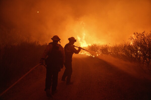 Firefighters work against the advancing Post Fire on Sunday, June 16, 2024, in Gorman, Calif. (AP Photo/Eric Thayer)