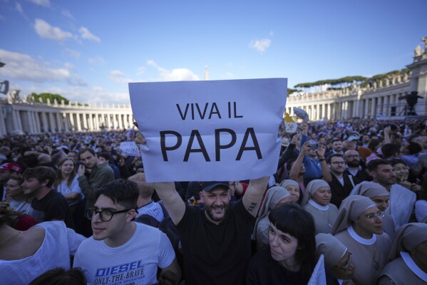Faithful hold a banner reading 