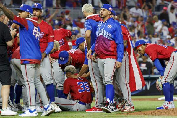 Puerto Rico pitcher Edwin Diaz (39) lies hurt on the field after injuring his knee celebrating a 5-2 win over the Dominican Republic at the World Baseball Classic at loanDepot Park on Wednesday, March 15, 2023, in Miami. (David Santiago/Miami Herald via AP)