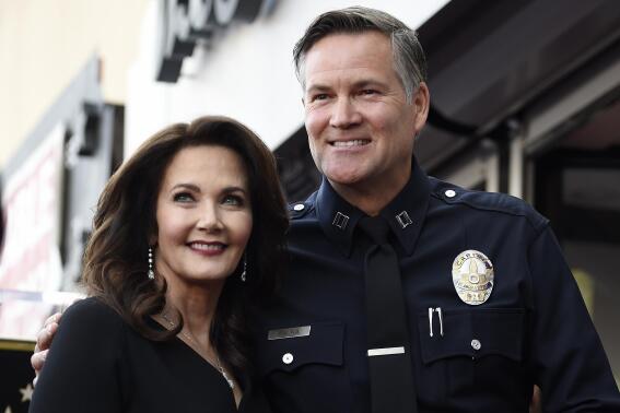 FILE - Actor Lynda Carter, left, poses with former Los Angeles Police Department Captain Cory Palka during a ceremony to award her a star on the Hollywood Walk of Fame, Tuesday, April 3, 2018, in Los Angeles. Palka's ties to Hollywood are under scrutiny after prosecutors say he leaked a sexual assault victim's confidential police report to CBS and its former leader Les Moonves. (AP Photo/Chris Pizzello, File)