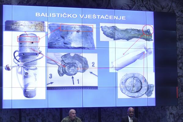 Photos of fragments of a bomb are displayed above officials in Zagreb, Croatia, Wednesday, April 13, 2022. A military drone that apparently flew all the way from the Ukrainian war zone over three European NATO-member states before crashing in an urban zone of the Croatian capital was armed with an explosive device, Croatia's crash investigators said Wednesday. (AP Photo)