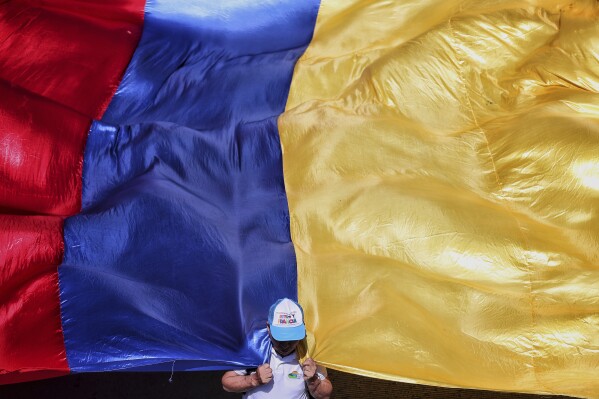 A demonstrator pulls a flag during a strike called by pro-government labor unions in support of reforms proposed by President Gustavo Petro in Cali, Colombia, Wednesday, May 28, 2025. (AP Photo/Santiago Saldarriaga)