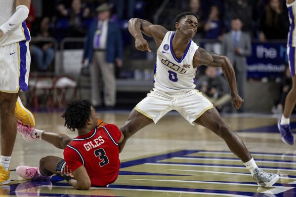 James Madison guard Xavier Brown (0) celebrates after forcing a jump ball against Radford guard Kenyon Giles (3) during the second half of an NCAA college basketball game in Harrisonburg, Va., Friday, Nov. 17, 2023. (Daniel Lin/Daily News-Record via AP)