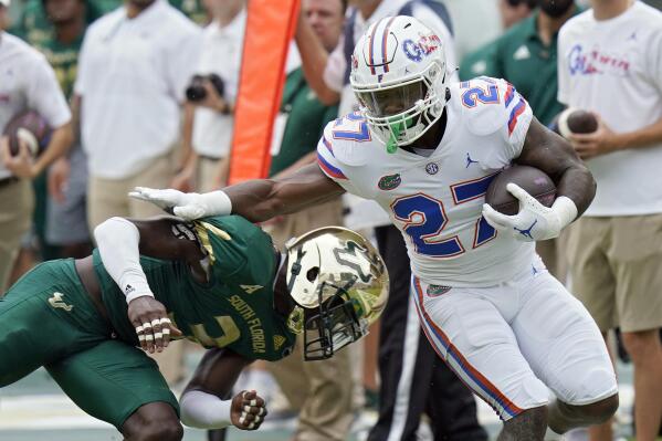 Florida running back Dameon Pierce (21) gets past South Florida safety Vincent Davis on a run during the first half of an NCAA college football game Saturday, Sept. 11, 2021, in Tampa, Fla. (AP Photo/Chris O'Meara)