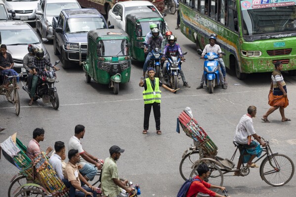 A student directs traffic in Dhaka, Bangladesh, on Aug. 8, 2024. (AP Photo/Rajib Dhar)